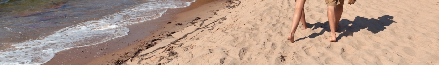 Basin Head Provincial Park, PEI Closeup image of couple walking in sand at Basin Head Beach