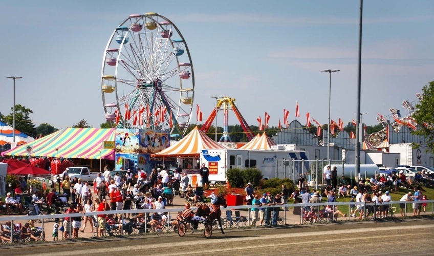 Old Home Week PEI’s Family Fun Fair Image of Prince Edward Island's Old Home Week Festival event grounds, including harness racing, festival tents and amusement rides.